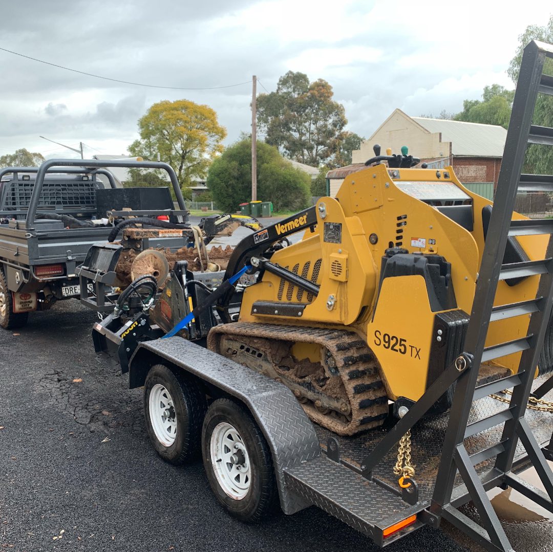 A ute and trailer loaded with a tracked mini loader
