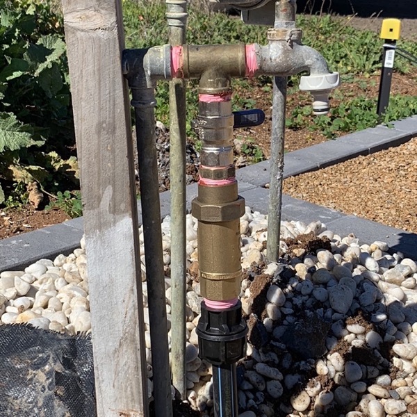Brass and steel riser pipework set into a bed of decorative stone