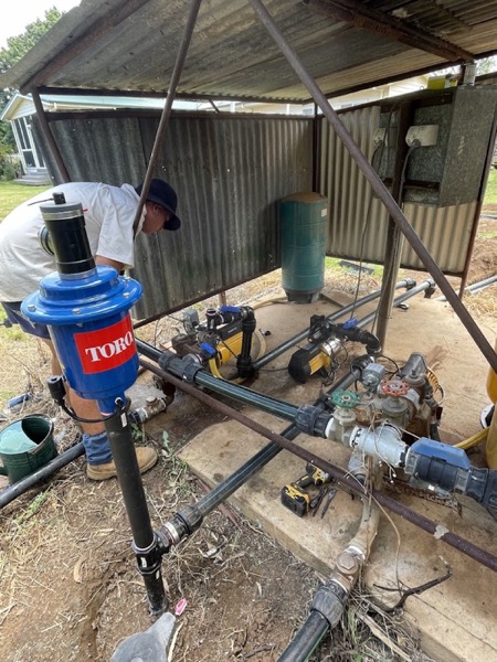 A pump, filter and valve assembly set up under a shed roof