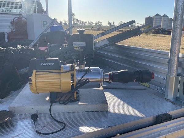 A pump and hose fitted in the back of a work vehicle