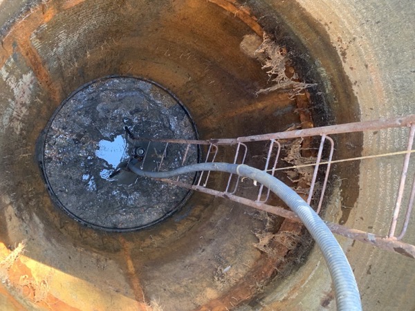 Looking down into a bore casing with a hose running into it