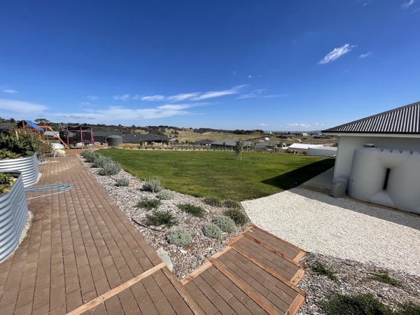 A brick path and lawn looking out over open country