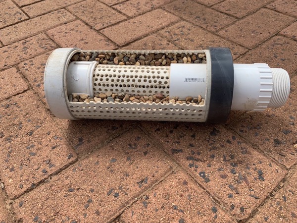 A filter cartridge and housing laid on paving